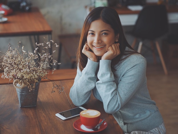 Portret van een jonge vrouw die in een café zit