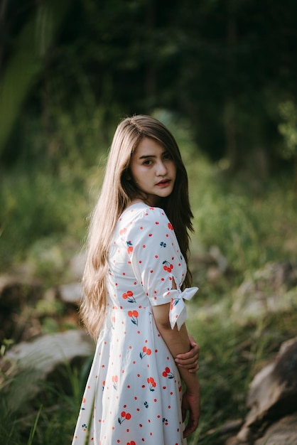 Portret van een jonge vrouw die in het bos staat