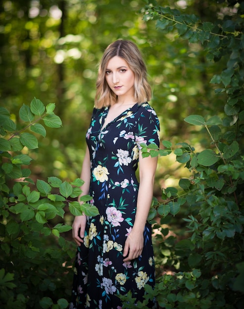 Portret van een jonge vrouw die in het bos staat