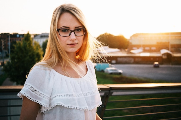 Portret van een jonge vrouw die in het park staat