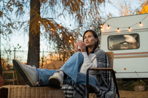 Foto portret van een jonge vrouw die in het park zit