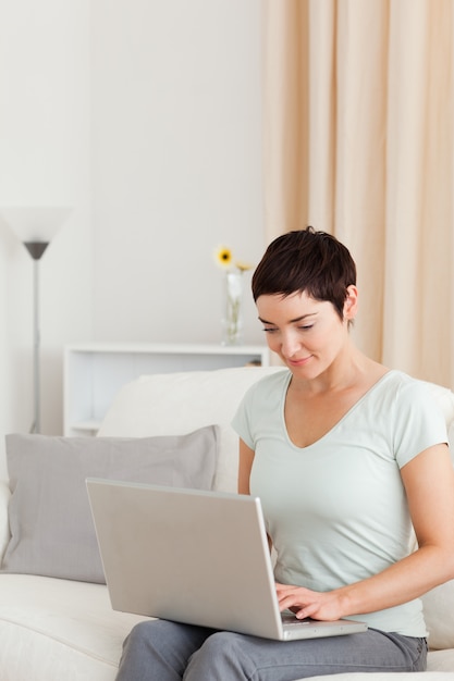 Portret van een jonge vrouw die met laptop werkt