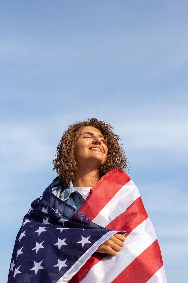 Foto portret van een jonge vrouw die naar de hemel kijkt met een amerikaanse vlag