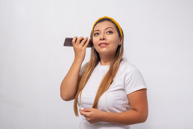 Portret van een jonge vrouw die naar haar mobiele telefoon luistert