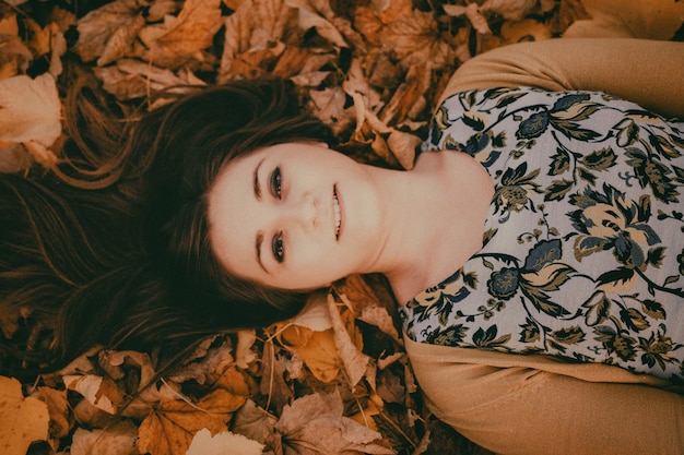 Portret van een jonge vrouw die op bed ligt