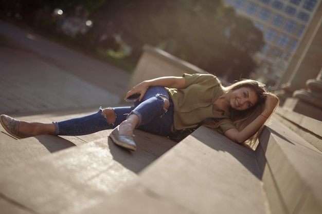 Foto portret van een jonge vrouw die op de trap ligt