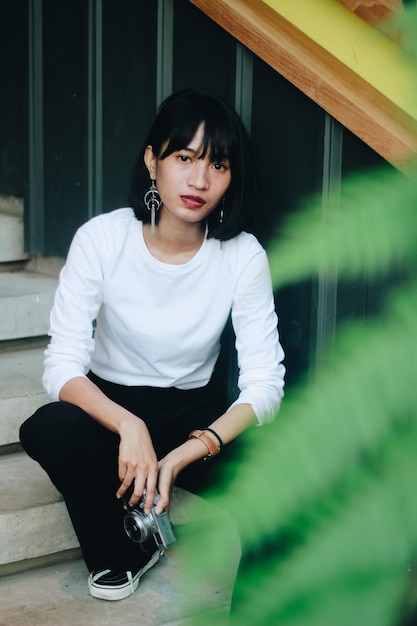 Portret van een jonge vrouw die op de trap zit