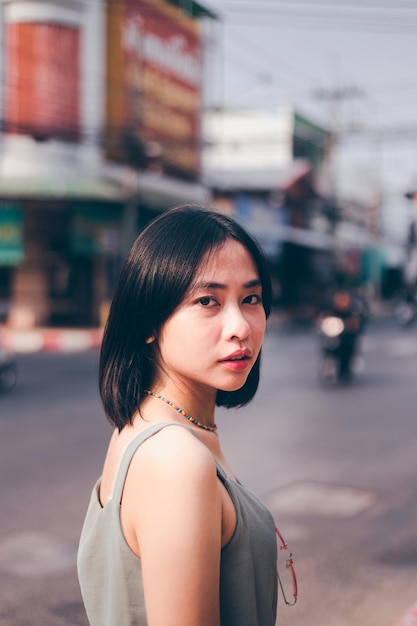 Portret van een jonge vrouw die op de weg in de stad staat