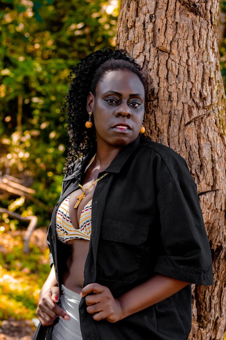 Foto portret van een jonge vrouw die op een boomstam staat