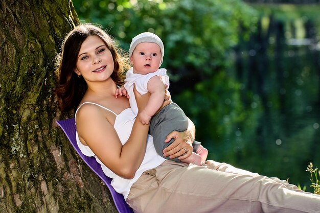 Foto portret van een jonge vrouw die op een boomstam zit