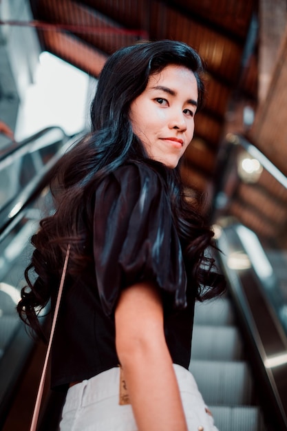 Portret van een jonge vrouw die op een roltrap staat