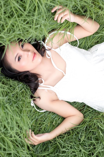 Portret van een jonge vrouw die op het gras ligt