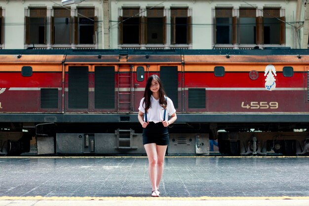 Portret van een jonge vrouw die op het perron van het treinstation staat