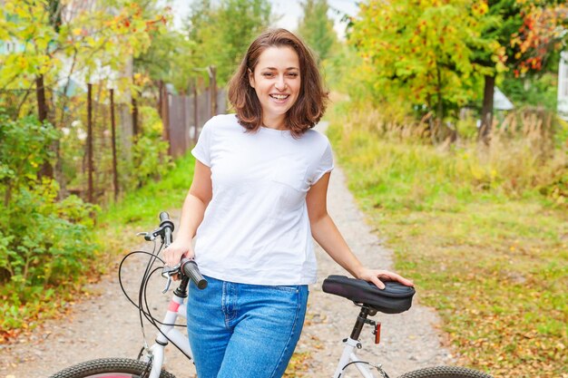 Foto portret van een jonge vrouw die op het veld fietsen