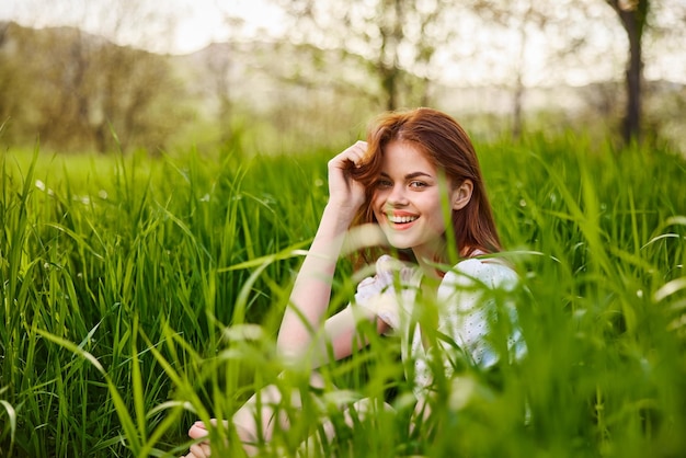 Portret van een jonge vrouw die op het veld zit