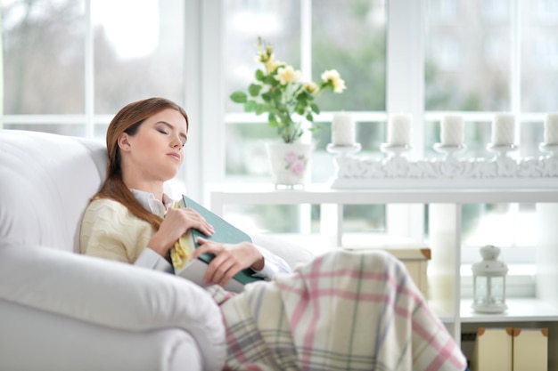 Portret van een jonge vrouw die slaapt met een boek