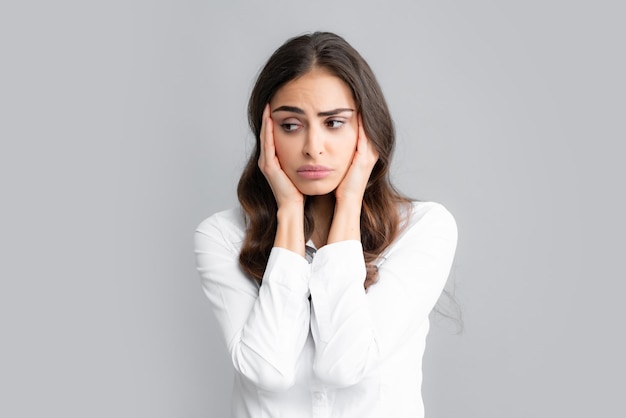 Portret van een jonge vrouw die stress of spanningshoofdpijn voelt Uitgeput vermoeid meisje wanhopig en gestrest omdat pijn en migraine Boos verdrietig depressief model met handen op het hoofd