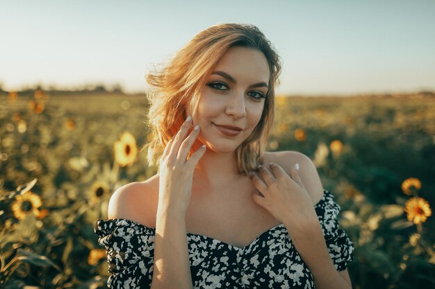 Portret van een jonge vrouw die te midden van planten op het veld staat