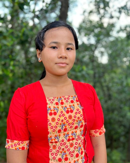 Foto portret van een jonge vrouw die tegen bomen staat