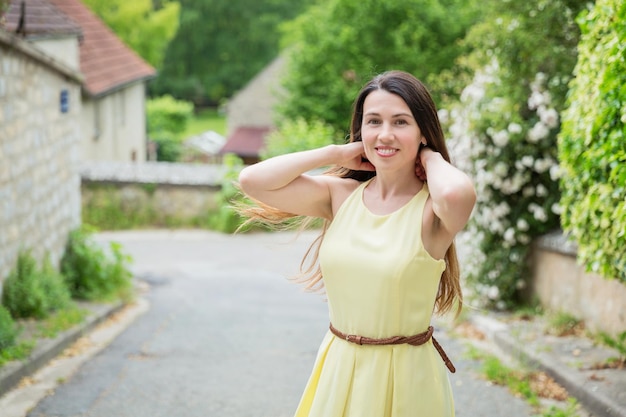Portret van een jonge vrouw die tegen bomen staat