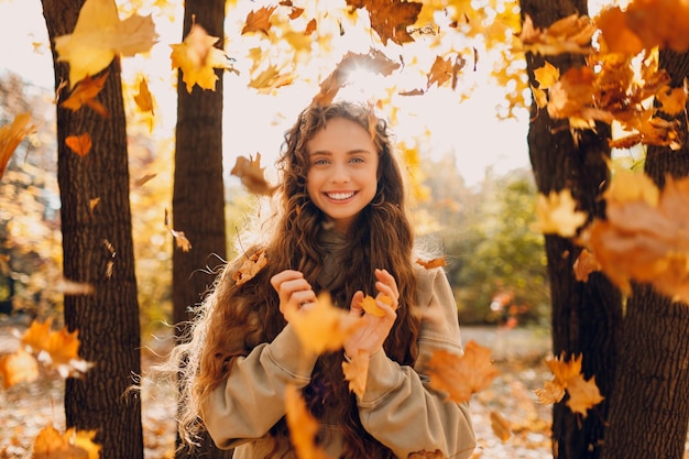 Portret van een jonge vrouw die tegen bomen staat