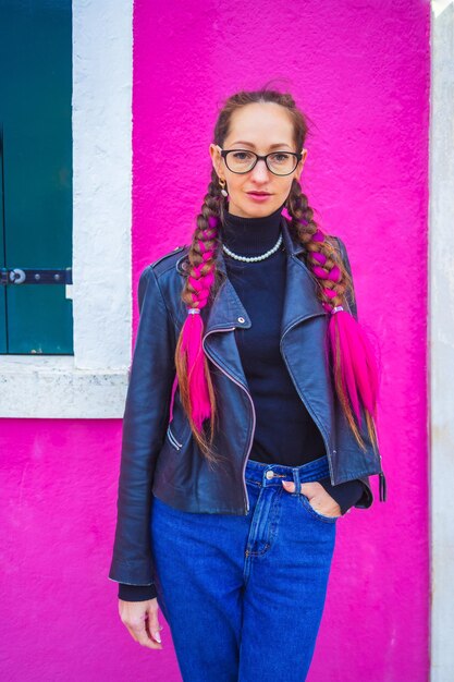 Foto portret van een jonge vrouw die tegen de gele muur staat