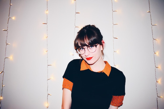 Portret van een jonge vrouw die tegen de muur staat