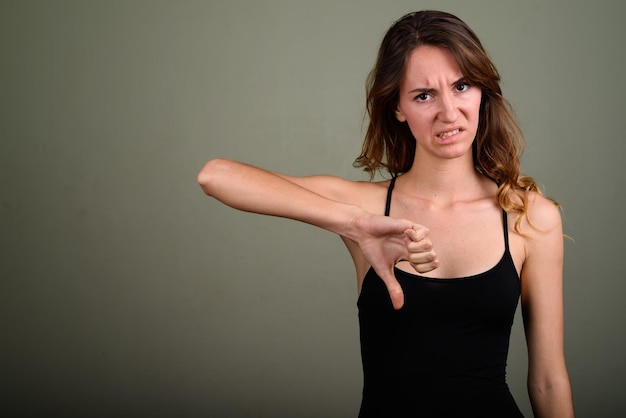 Foto portret van een jonge vrouw die tegen de muur staat