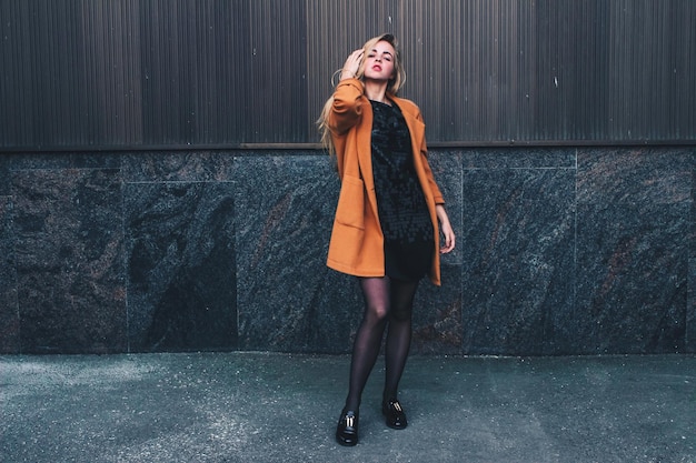 Portret van een jonge vrouw die tegen de muur staat
