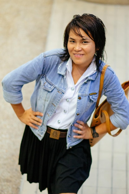 Foto portret van een jonge vrouw die tegen de muur staat