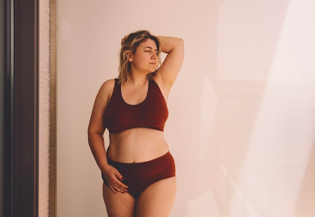 Portret van een jonge vrouw die tegen de muur staat