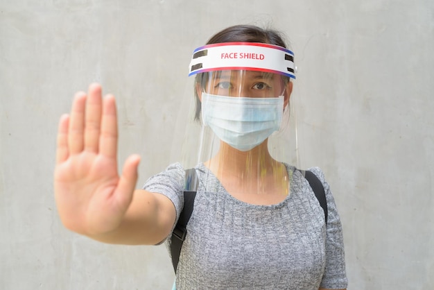 Foto portret van een jonge vrouw die tegen de muur staat