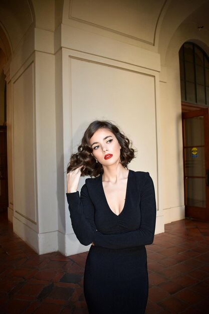 Foto portret van een jonge vrouw die tegen de muur staat