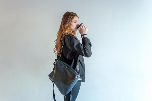 Portret van een jonge vrouw die tegen de muur staat