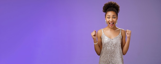 Foto portret van een jonge vrouw die tegen een blauwe achtergrond staat