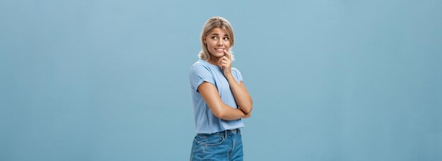 Foto portret van een jonge vrouw die tegen een blauwe achtergrond staat