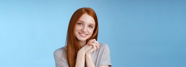 Foto portret van een jonge vrouw die tegen een blauwe achtergrond staat