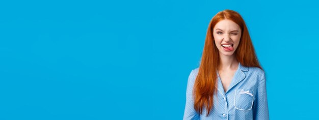 Foto portret van een jonge vrouw die tegen een blauwe achtergrond staat