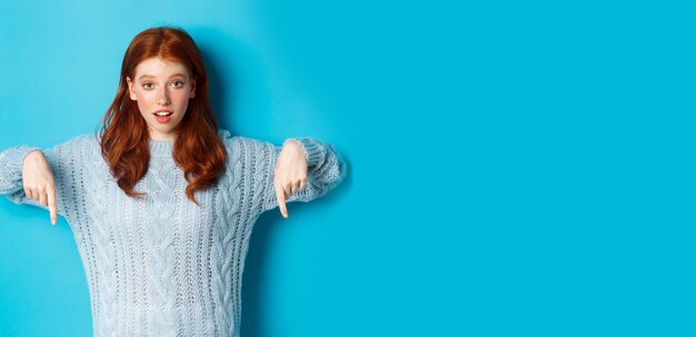 Foto portret van een jonge vrouw die tegen een blauwe achtergrond staat