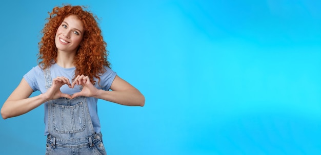 Foto portret van een jonge vrouw die tegen een blauwe achtergrond staat