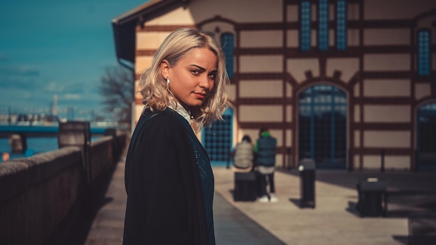 Portret van een jonge vrouw die tegen een gebouw staat