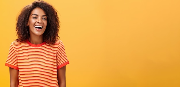 Foto portret van een jonge vrouw die tegen een gele achtergrond staat