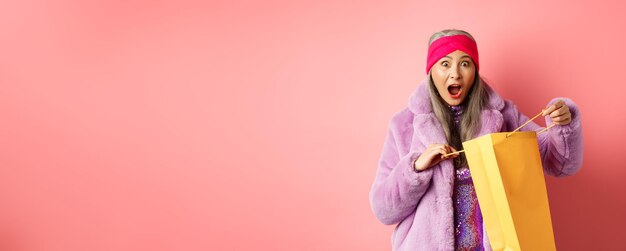 Foto portret van een jonge vrouw die tegen een gele achtergrond staat