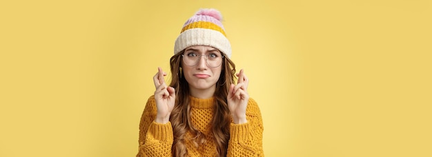 Foto portret van een jonge vrouw die tegen een gele achtergrond staat