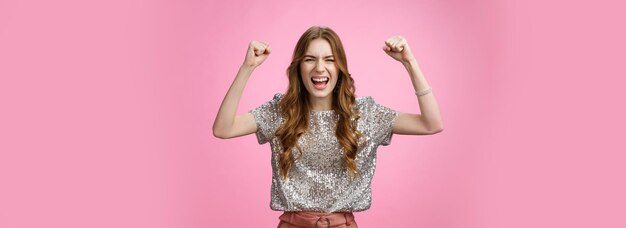 Portret van een jonge vrouw die tegen een gele achtergrond staat