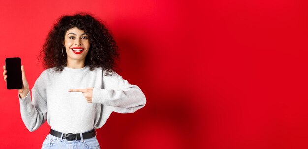 Foto portret van een jonge vrouw die tegen een gele achtergrond staat