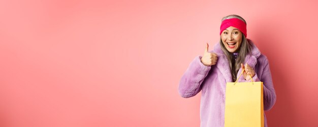 Foto portret van een jonge vrouw die tegen een gele achtergrond staat