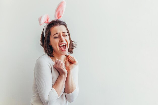 Portret van een jonge vrouw die tegen een grijze achtergrond staat