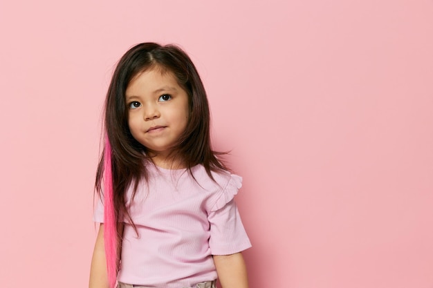 Portret van een jonge vrouw die tegen een roze achtergrond staat