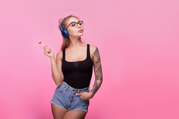 Portret van een jonge vrouw die tegen een roze achtergrond staat